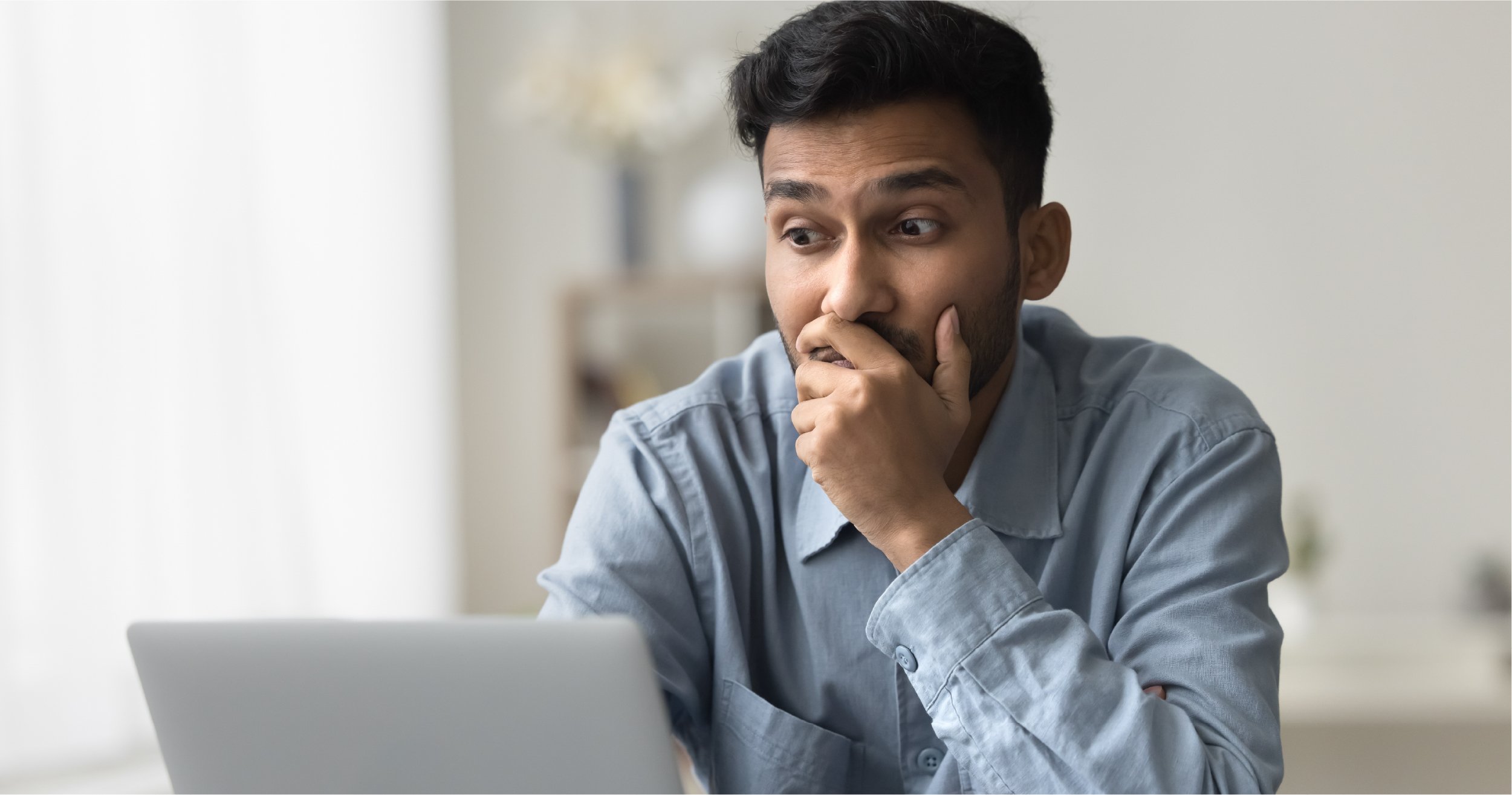 Employee looking at unpleasant information on their computer.