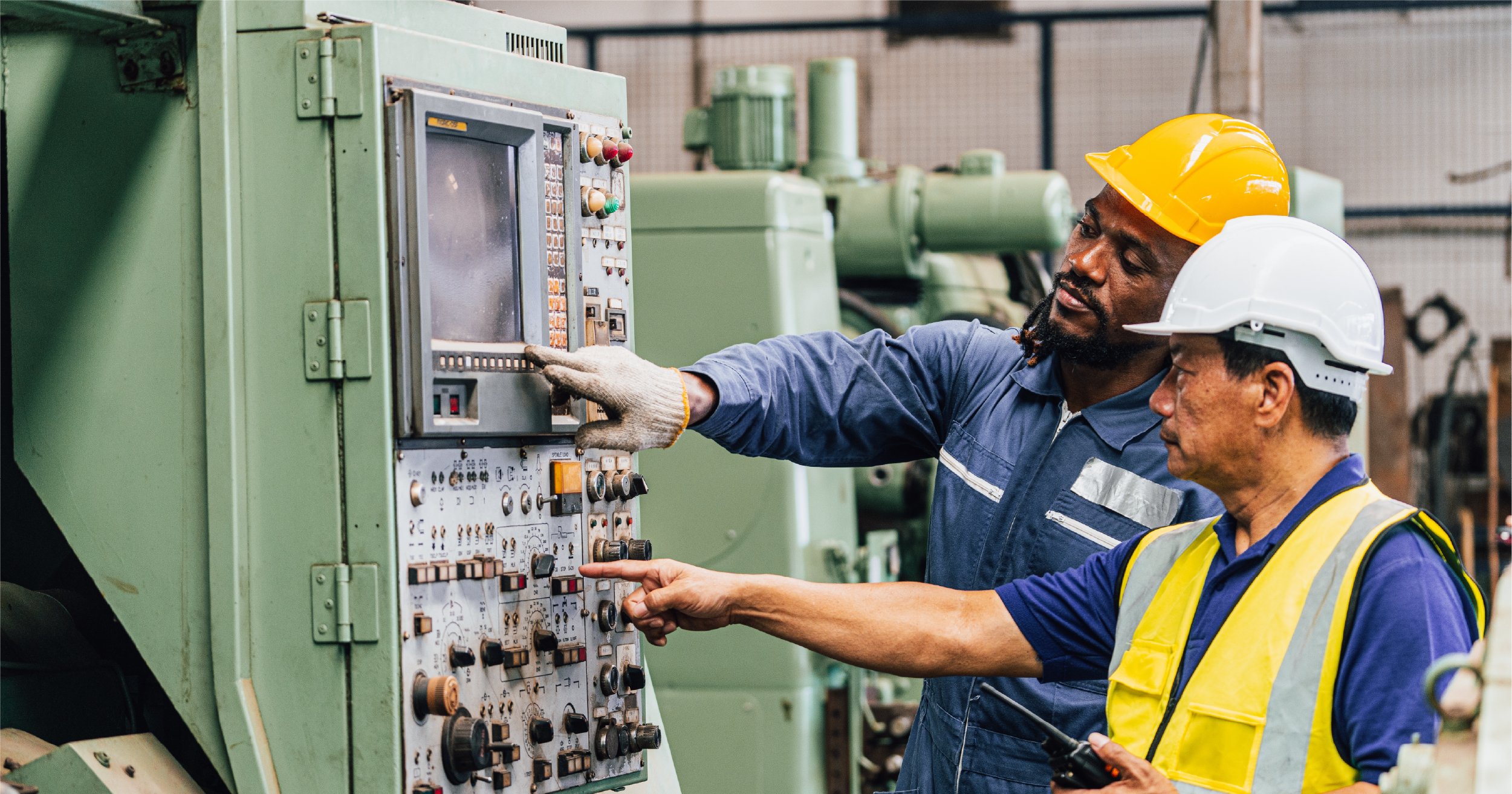 Factory workers looking at technology. 