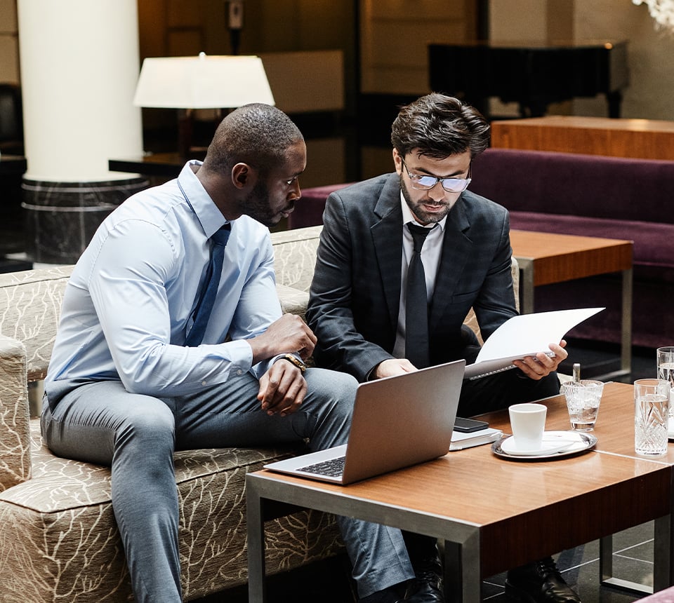 Two business professionals conversing with business materials