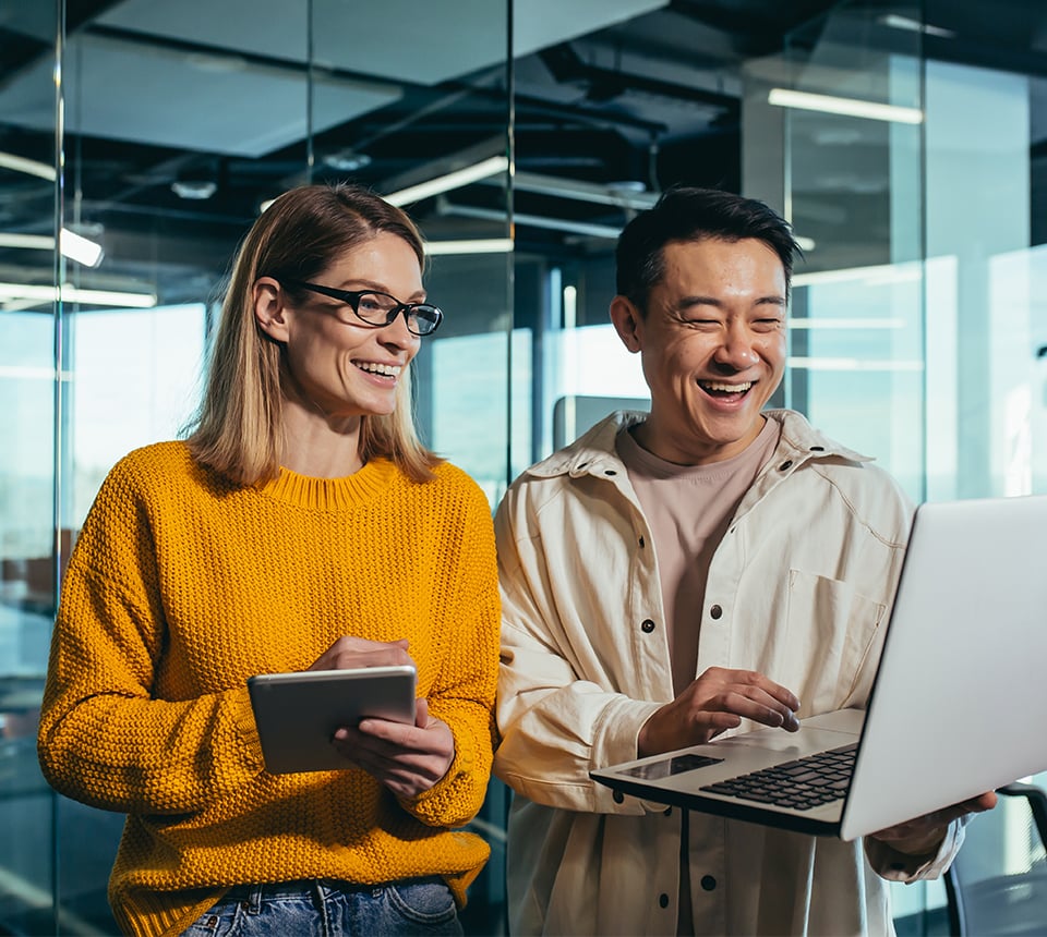 Man and woman looking at laptop and conversing