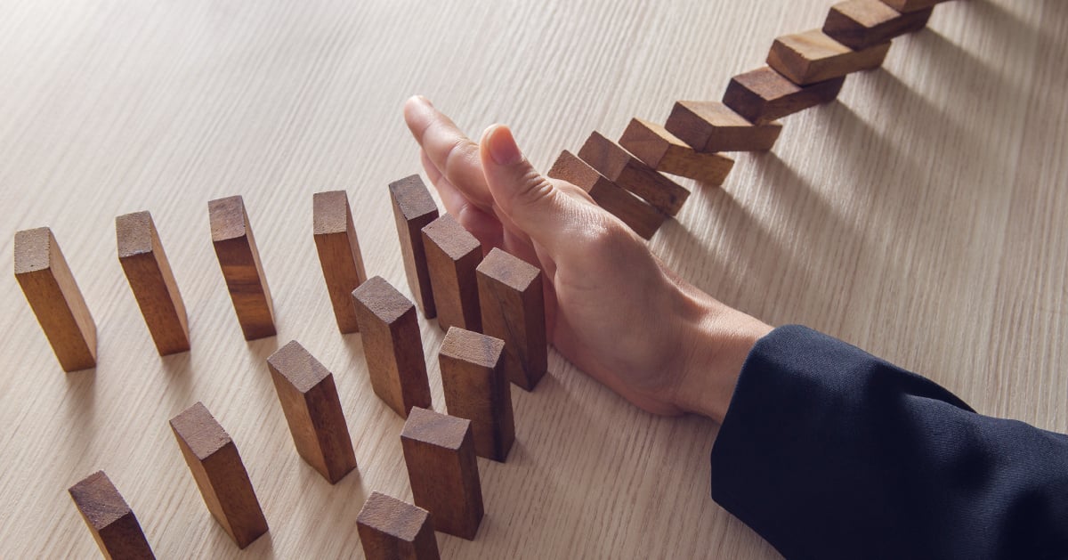 Business owner stopping risks' domino effect.