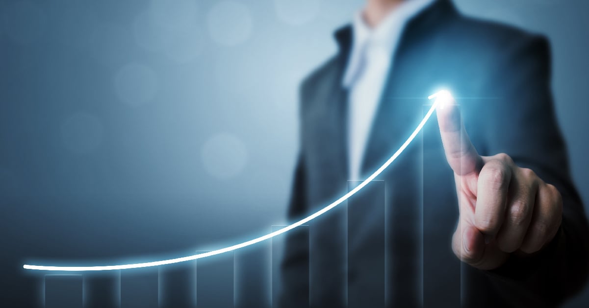 A businessman traces the upward trajectory of his business goals in a digitized bag graph.