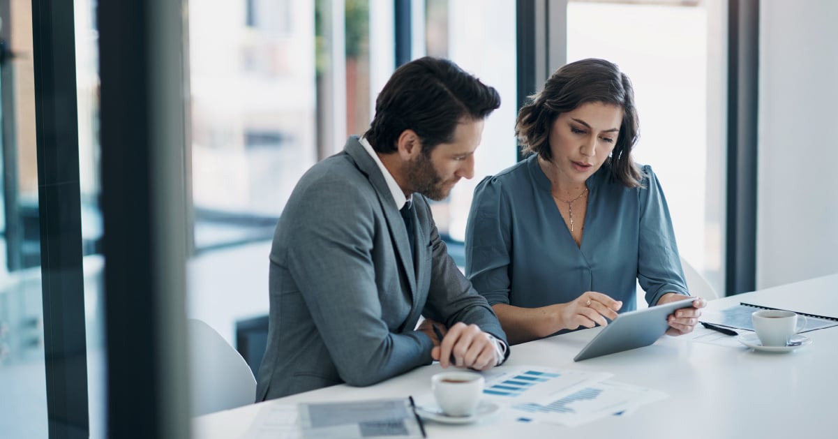 A male and female worker collaborate on implementing IT lifecycle management at their business.