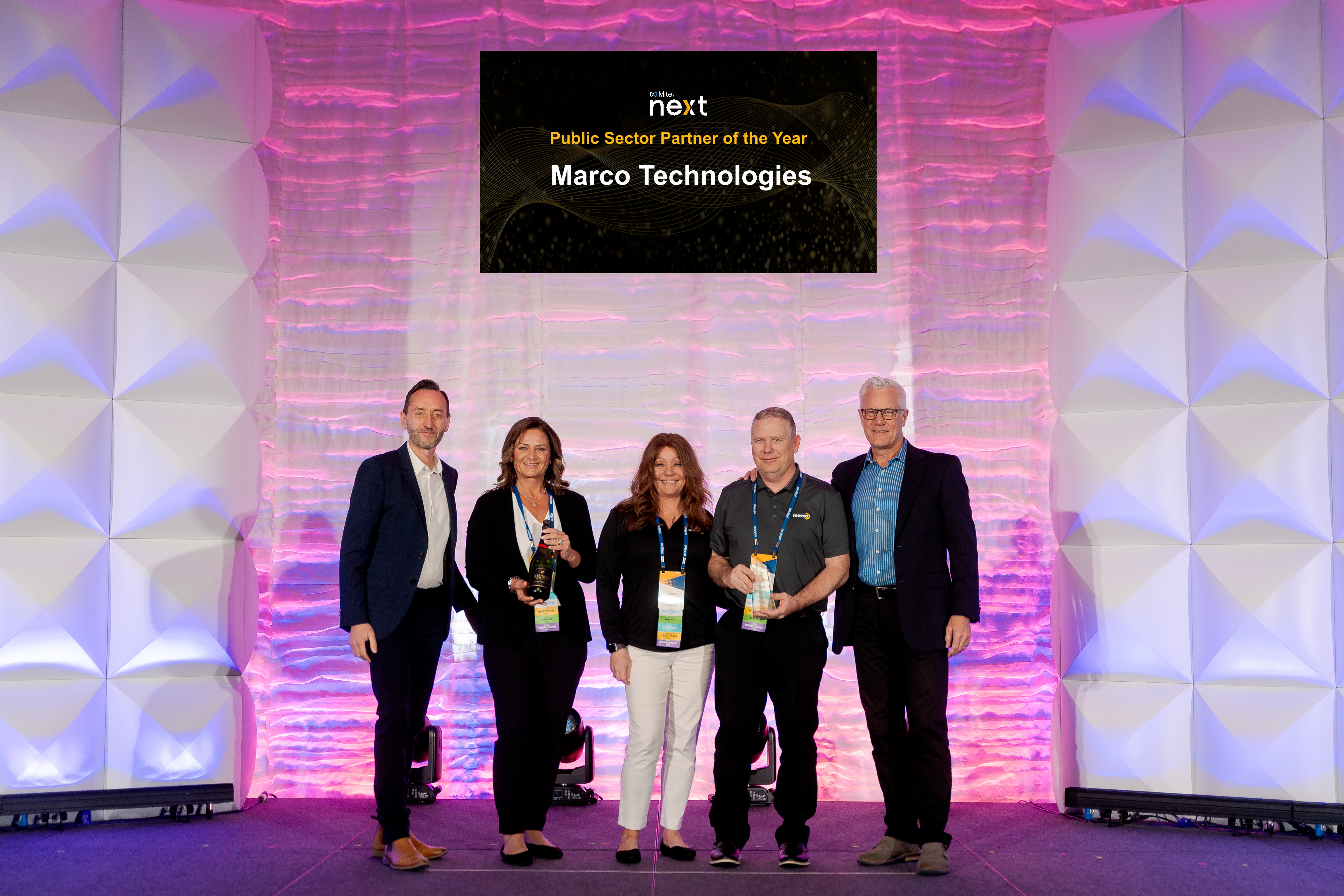 Marco Technologies employees accept Mitel's Public Sector Partner of the Year award in 2024.