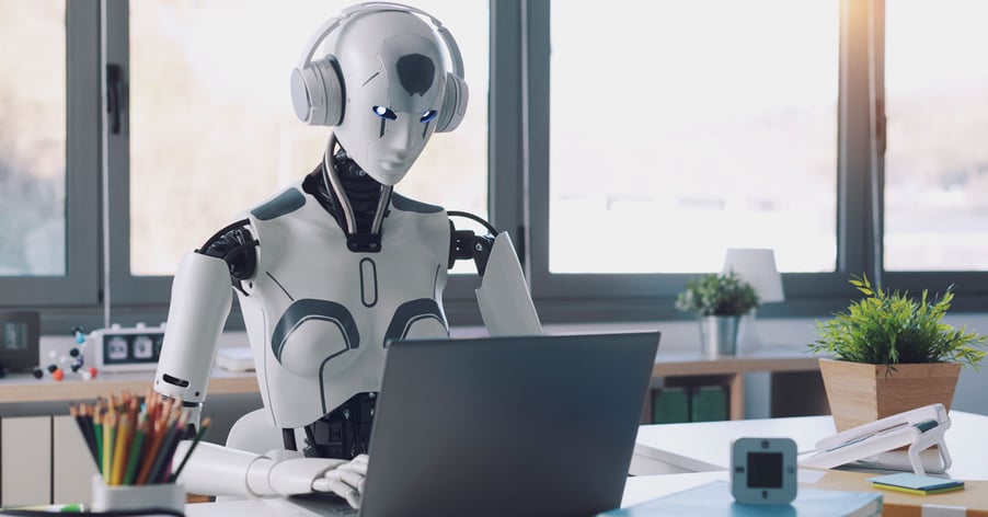 Robot wearing headphones and using laptop in office.