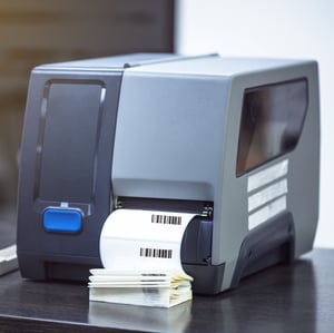 A thermal printer generates a series of bar codes in a business setting.
