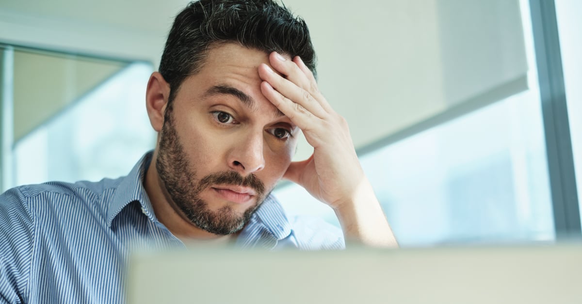 Concerned businessman looking at laptop. 