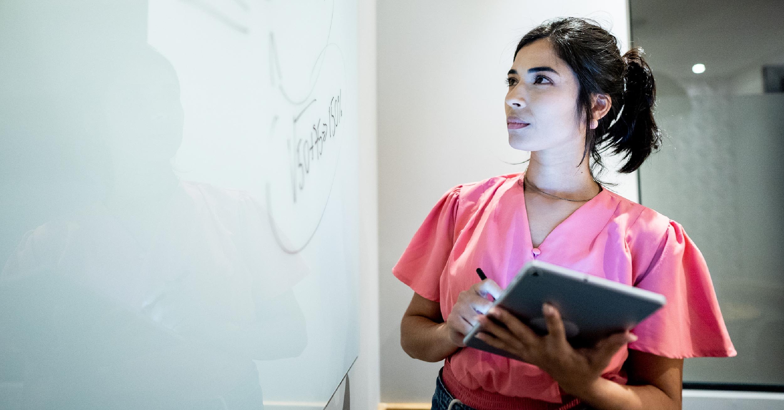 woman-holding-tablet-by-whiteboard