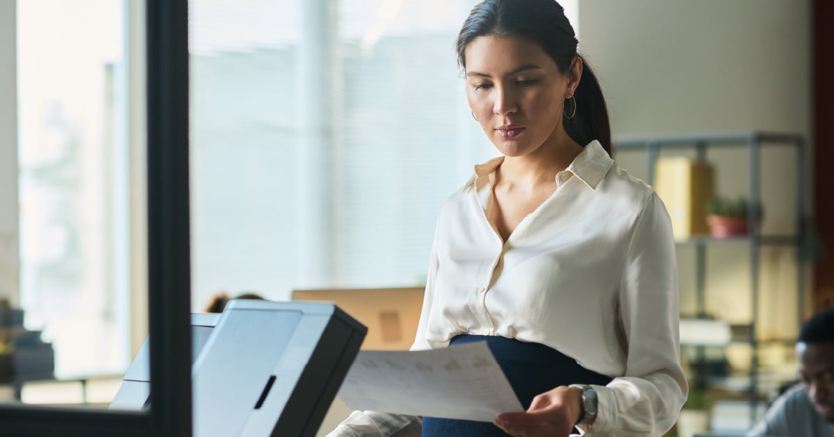 A female businesswoman tracks her company's printing costs using sophisticated print management software.